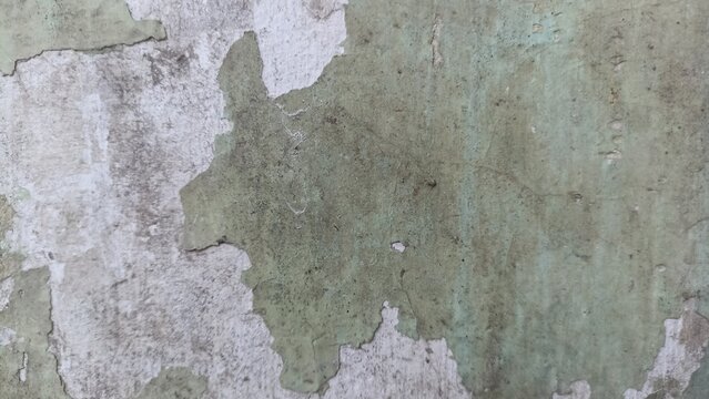 Peeling Green Paint Texture Background showing a distressed aged wall with exposed white plaster and worn green coating, ideal for grunge art, vintage designs, and rustic backdrops
