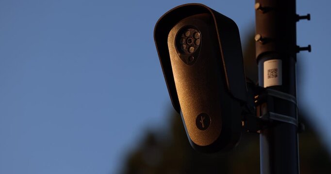 Fullerton, California, USA - July 23, 2026: An AI camera surveils a city street for car license plates.