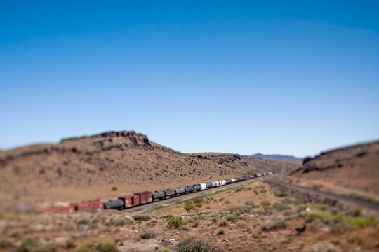 A long freight train winds through desert hills