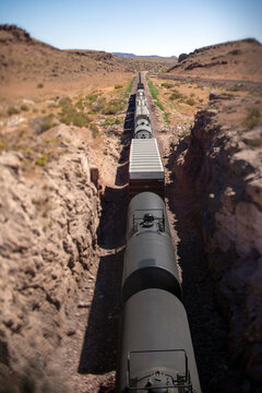Long freight train travels through a desert canyon