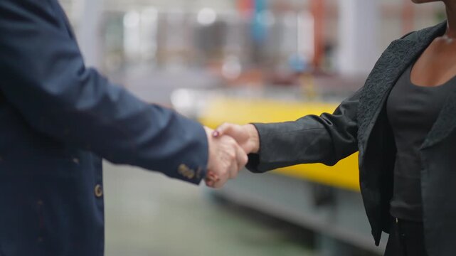Investors in the manufacturing industry shake hands in the factory to discuss the purchase of machinery, procurement of goods, or discussions about increasing investment in factory technology machiner