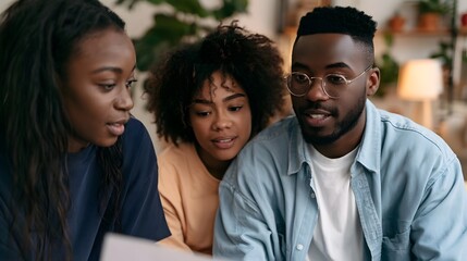 Fototapeta premium Three people closely examining a document together in a warmly lit indoor space with plants and soft background lighting