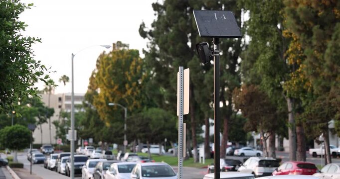 Fullerton, California, USA - July 23, 2026: An AI camera surveils a city street for car license plates.
