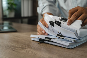 Business office data document graph chart report beside laptop, organizing file bundles for records management, document handling, filing workflow with copy space.