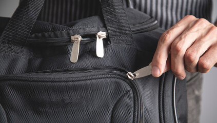 Man using zipper on sports backpack. © andranik123