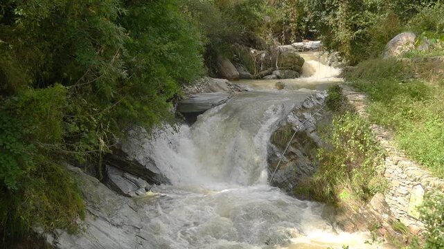 Fast Flowing Waterfall and River Stream Cascading Over Rocks in Forest