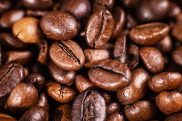 Fototapeta premium Close-up of roasted coffee beans and a coffee pod on a brown background