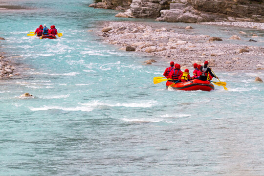 Whitewater rafting teams navigate down a turquoise mountain Fella river, experiencing adventure and outdoor tourism lifestyle in the Julian Alps Natural Park, Resia, Friuli Venezia Giulia, Italy.