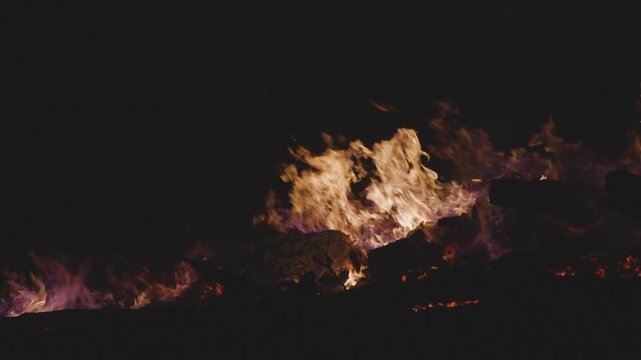 Fire embers particles over black background. Fire sparks background. Abstract dark glitter fire particles lights. 4K Video. 