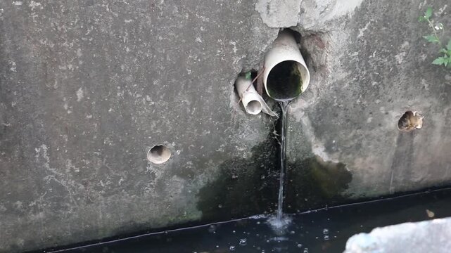 Wastewater Flowing from PVC Drain Pipe into Concrete Drainage Channel