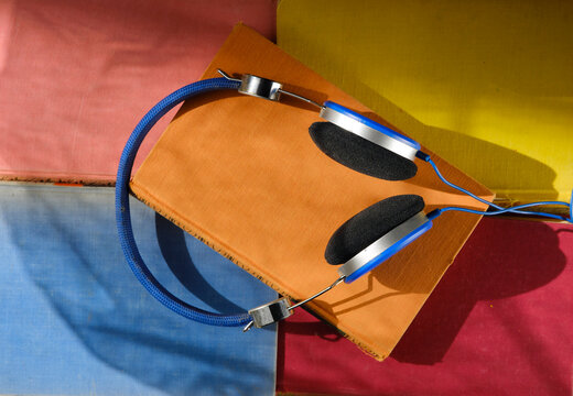 audiobooks with headphones and multicolored books. Podcasting, listening,literature,media,education concept