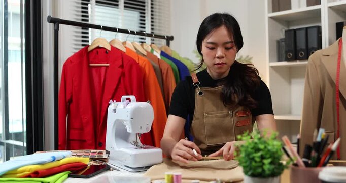 Fashion designer creating garment patterns, measuring fabric, inspecting clothing quality, and preparing apparel in a professional studio for tailoring, production, and fashion design workflow.