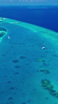 A serene aerial view of the tranquil tropical reef in the Maldives, showcasing clear blue water and sandy beaches under a sunny holiday atmosphere. This high-altitude perspective offers.