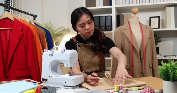 Fashion designer creating garment patterns, measuring fabric, inspecting clothing quality, and preparing apparel in a professional studio for tailoring, production, and fashion design workflow.