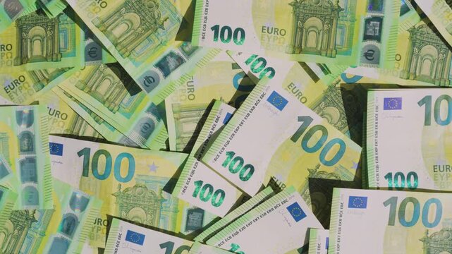 Macro close-up of many 100 euro notes focusing on fine details, security elements and texture, illustrating wealth and cash money concept. 4K Video.