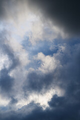 Fototapeta premium Dramatic sky with dark and bright clouds and patches of blue sky