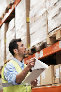 Clipboard, man and shipping inventory in warehouse for order picking, stock count or inspection. Logistics, supervisor and checklist for tracking inbound cargo, verify storage backlog or distribution
