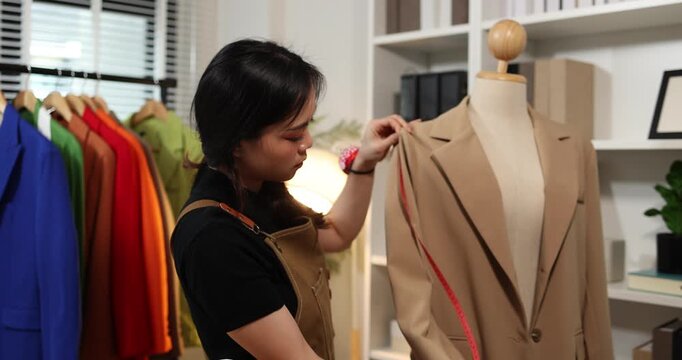 Fashion designer creating garment patterns, measuring fabric, inspecting clothing quality, and preparing apparel in a professional studio for tailoring, production, and fashion design workflow.