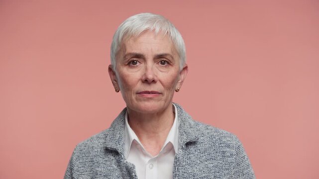 Senior Woman Speaking During Online Video Call on Pink