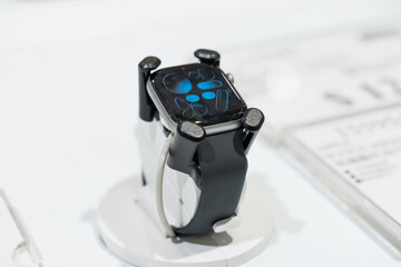 Naklejka premium Apple Watch models are displayed in a modern retail environment featuring various case finishes and watch bands. Close-up photographs emphasize the digital display, precision craftsmanship, health sen