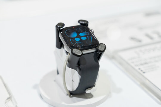 Apple Watch models are displayed in a modern retail environment featuring various case finishes and watch bands. Close-up photographs emphasize the digital display, precision craftsmanship, health sen
