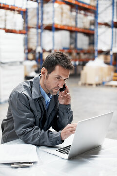 Logistics, laptop or man with phone call in factory for inventory update, order status or export. Warehouse, dispatcher and contact courier on tech for shipping enquiry, track parcel and supply chain