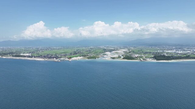 高気温であり高湿度でもある日本の富山県東部を流れる黒部川河口付近の様子と積乱雲