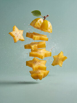 Fresh starfruit with floating carambola slices and liquid splash, healthy food background