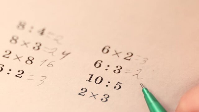 Math homework in notebook with multiplication and division exercises written with pencil showing elementary education learning process calculation practice and student study activity