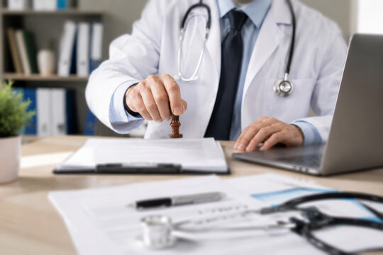 Doctor approval Physician stamps consent on medical document at hospital office to finalize signature and ensure healthcare compliance, updating records for safe treatment. concept policy and trust.