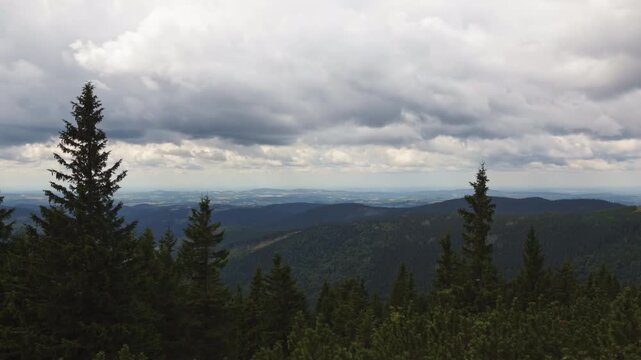 Beautiful timelapse of dramatic storm clouds moving over the valley and pine forests in Krkonose Mountains