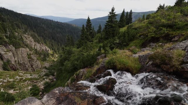 Scenic view of Elbe Waterfall flowing into Elbe Valley under a cloudy sky, Krkonose National Park, Czech Republic