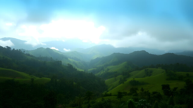 A wide-angle cinematic shot of lush green rolling hills and mountains shrouded in mist and fog, ethereal morning sunlight breaking through dramatic blue clouds, moody light, vibrant green valleys, ult