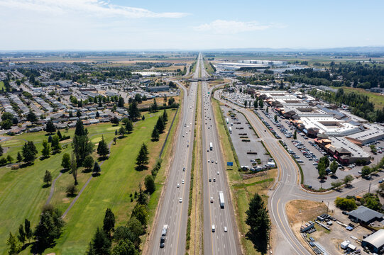 Aerial drone photo of Interstate 5 (I-5) and highway interchange with connecting ramps near Woodburn, Oregon, USA showing regional transportation infrastructure and commuter traffic