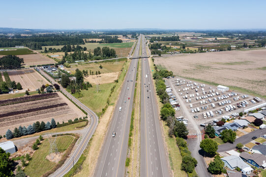 Aerial drone photo of Interstate 5 (I-5) and highway interchange with connecting ramps near Woodburn, Oregon, USA showing regional transportation infrastructure and commuter traffic