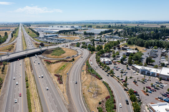 Aerial drone photo of Interstate 5 (I-5) and highway interchange with connecting ramps near Woodburn, Oregon, USA showing regional transportation infrastructure and commuter traffic