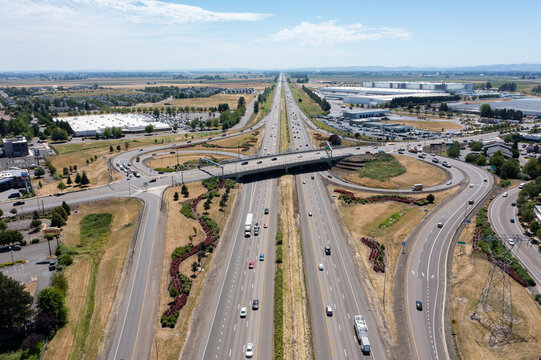 Aerial drone photo of Interstate 5 (I-5) and highway interchange with connecting ramps near Woodburn, Oregon, USA showing regional transportation infrastructure and commuter traffic