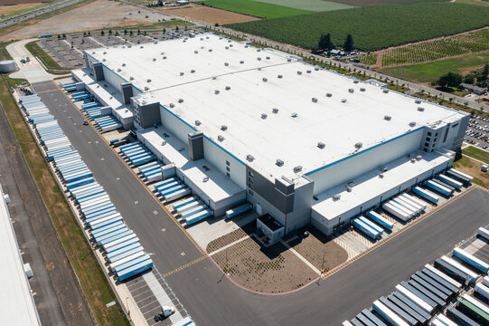 Woodburn, Oregon, USA - June 19, 2026 - Aerial drone photo of Amazon Fulfillment Center PDX8 with warehouse buildings, loading docks, trailers and logistics operations