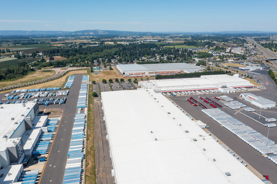 Woodburn, Oregon, USA - June 19, 2026 - Aerial drone photo of Amazon Fulfillment Center PDX8 with warehouse buildings, loading docks, trailers and logistics operations