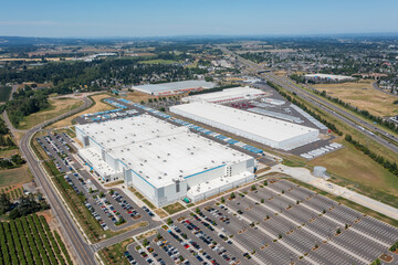Fototapeta premium Aerial drone photo of major ecommerce fulfillment and grocery distribution centers in Woodburn, Oregon, USA with warehouses, loading docks, trailers and logistics operations