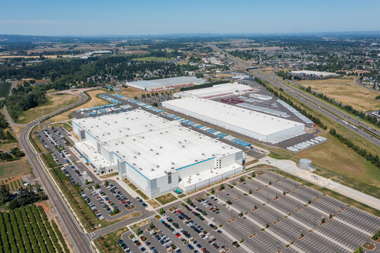 Aerial drone photo of major ecommerce fulfillment and grocery distribution centers in Woodburn, Oregon, USA with warehouses, loading docks, trailers and logistics operations