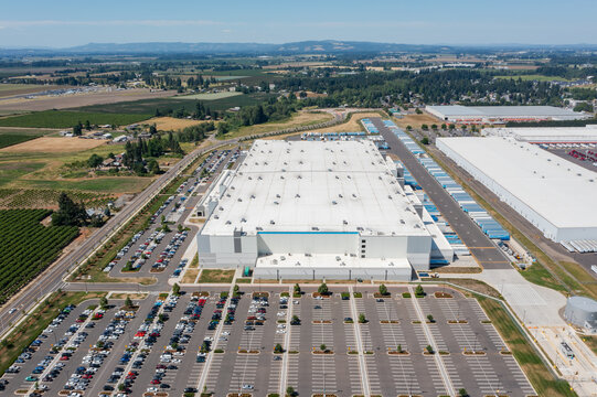 Aerial drone photo of major ecommerce fulfillment and grocery distribution centers in Woodburn, Oregon, USA with warehouses, loading docks, trailers and logistics operations