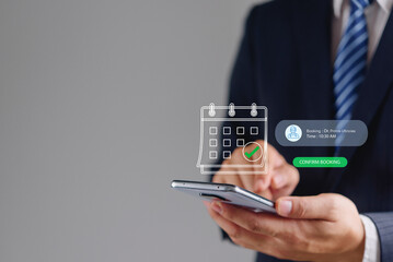Plakat Businessman using smartphone with digital medical appointment booking calendar hologram in online healthcare concept. Professional confirming doctor schedule via modern application.