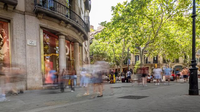 Timelapse of a bustling crowd walking along the luxurious Passeig de Gracia in Barcelona, a famous avenue known for its high end shopping, architecture, and vibrant city life