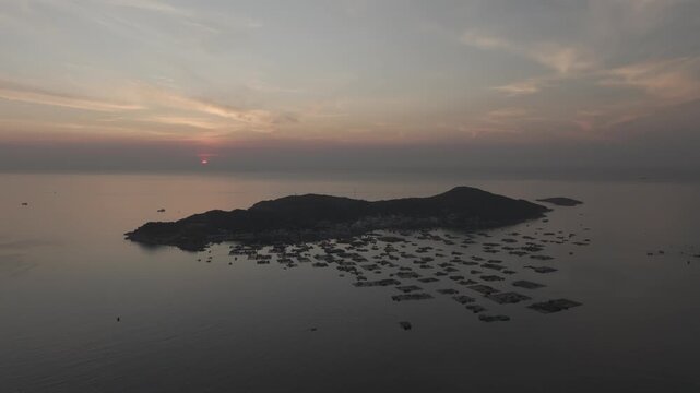 Aerial drone footage of sunrise over Binh Hung Island and its stunning coastline in Khanh Hoa, Vietnam, featuring turquoise waters, rocky shores and breathtaking tropical seascapes.