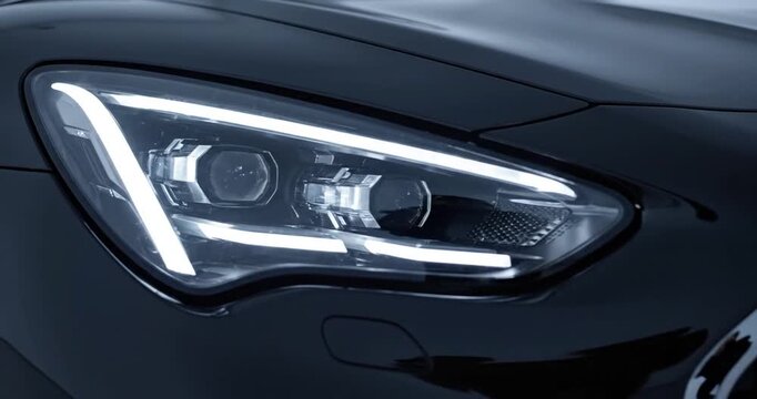 Close-up of a sleek car headlight and sleek black design, showcasing modern engineering and luxury