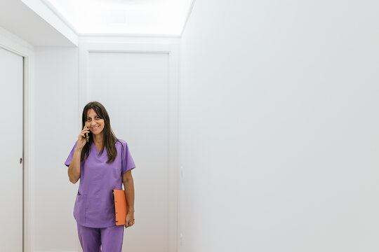 Optometrist walking and talking on the phone at her practice