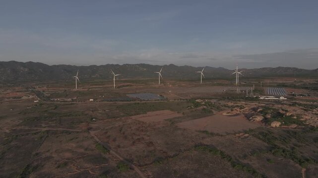 Aerial drone footage of Wind Farm in Phuoc Dinh, Khanh Hoa, Vietnam, featuring giant wind turbines along the coastal landscape, showcasing renewable energy, sustainable power and clean technology.