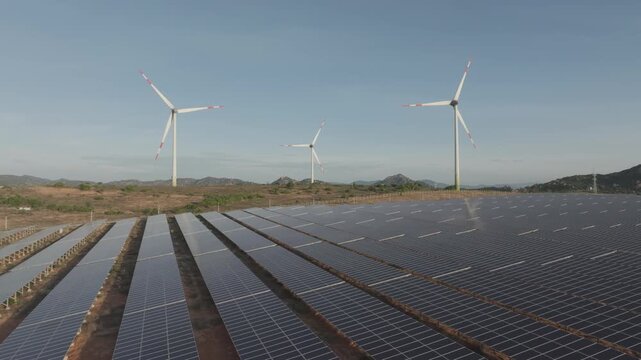 Aerial drone footage of Phuoc Dinh Renewable Energy Complex in Khanh Hoa, Vietnam, featuring solar panels and wind turbines, showcasing clean energy, sustainable power and green technology.