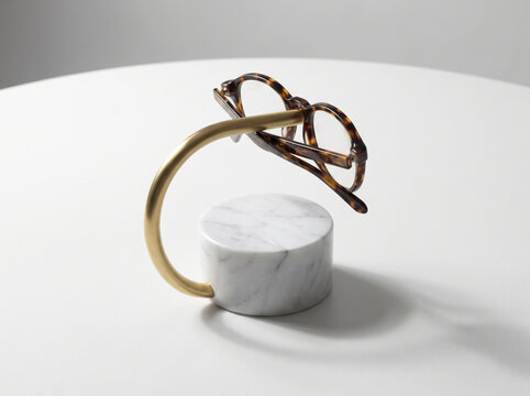 Elegant marble and brass glasses stand on white surface